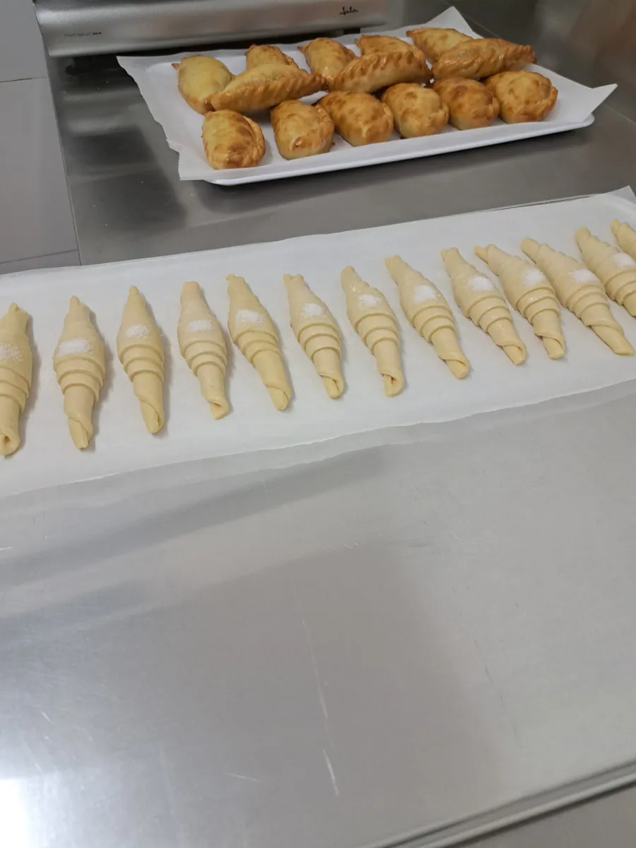 Bandeja con empanadas y croissants recién hechos en Doca's Coffee